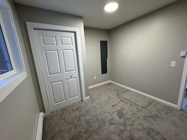 unfurnished bedroom with a baseboard heating unit, carpet flooring, and baseboards