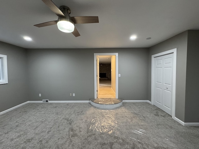 spare room featuring visible vents, baseboards, a ceiling fan, and carpet