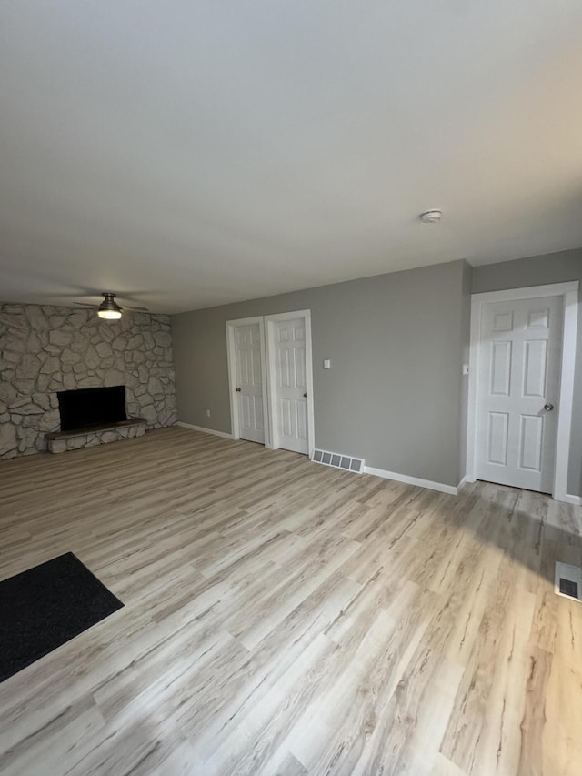unfurnished living room featuring visible vents, a ceiling fan, and wood finished floors