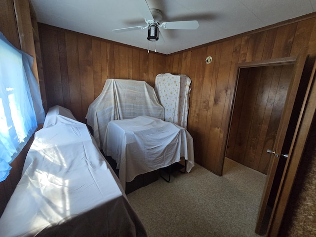 2051 Stutesman Dr, Fairview, MI 48621 - bedroom featuring wood walls, ceiling fan, and carpet flooring