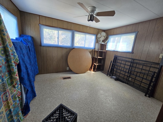 2051 Stutesman Dr, Fairview, MI 48621 - interior space with wooden walls, visible vents, a ceiling fan, and carpet flooring
