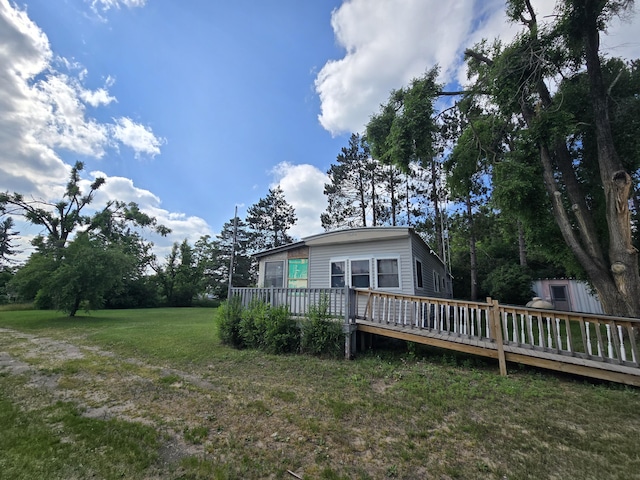 2051 Stutesman Dr, Fairview, MI 48621 - back of house with a wooden deck and a lawn