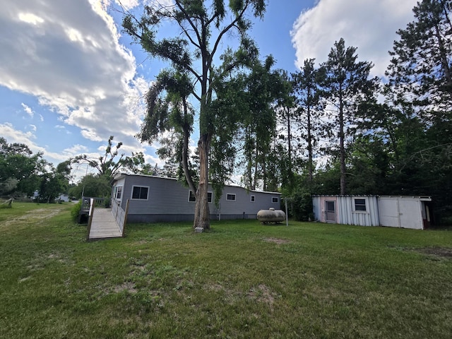 2051 Stutesman Dr, Fairview, MI 48621 - view of grassy yard with an outbuilding