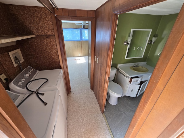 2051 Stutesman Dr, Fairview, MI 48621 - half bath featuring washer / dryer, wooden walls, and vanity