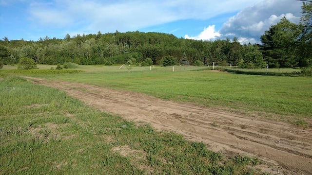 surrounding community with a view of trees, a yard, and a rural view