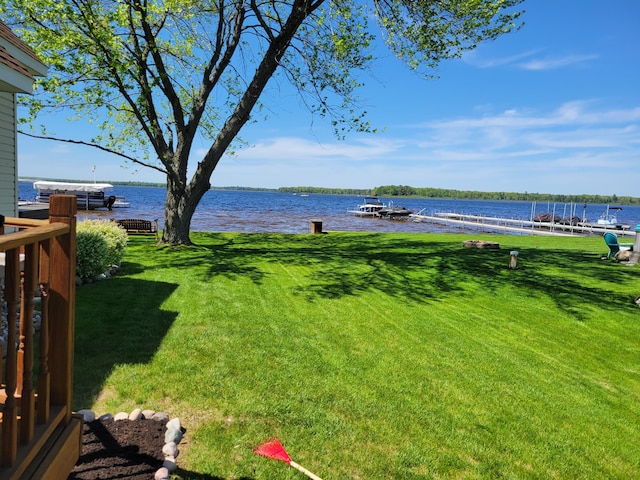 view of yard with a boat dock and a water view