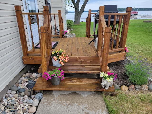 wooden deck featuring a yard and a water view