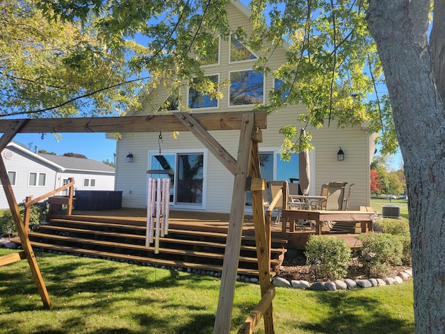 back of property with a yard and a wooden deck