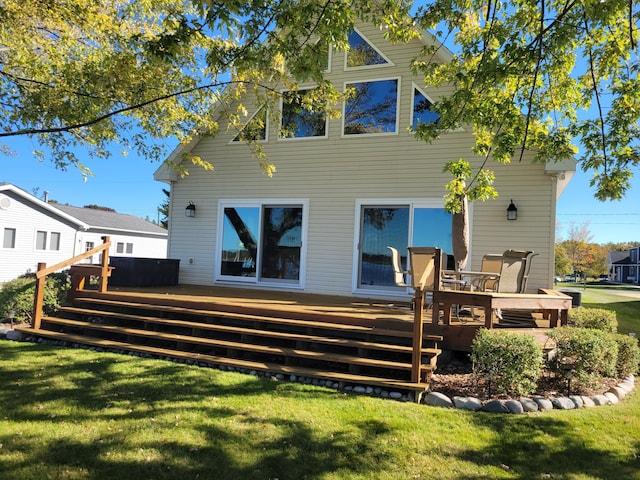 rear view of house featuring a yard and a deck