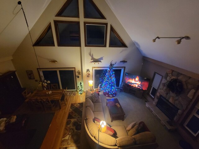 living area featuring wood finished floors, a fireplace with raised hearth, and vaulted ceiling