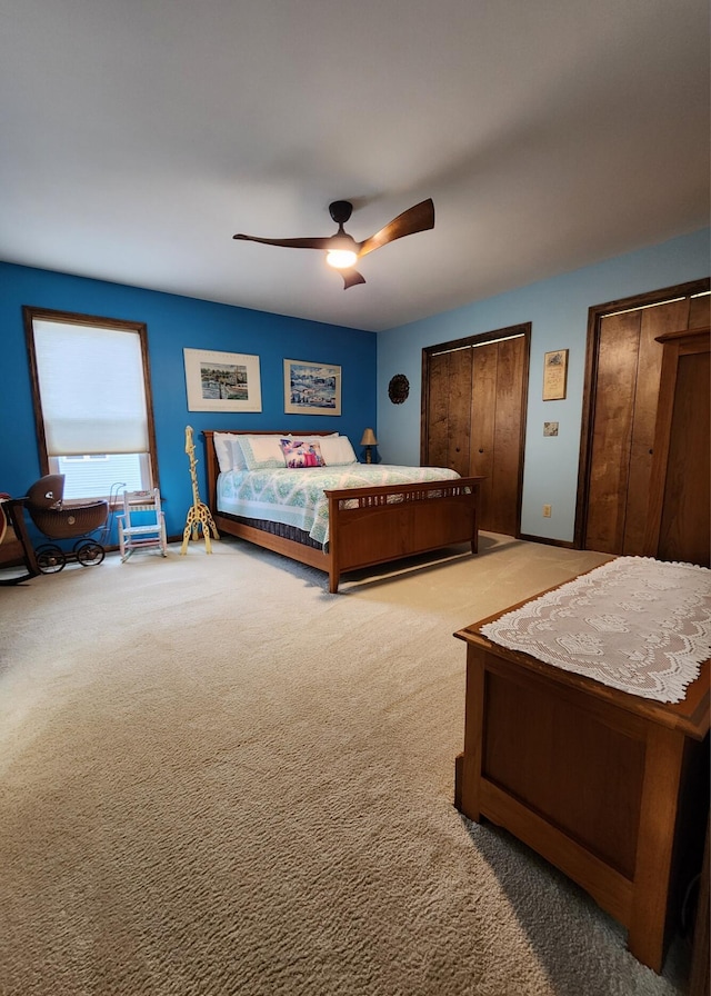 bedroom featuring multiple closets, a ceiling fan, and carpet