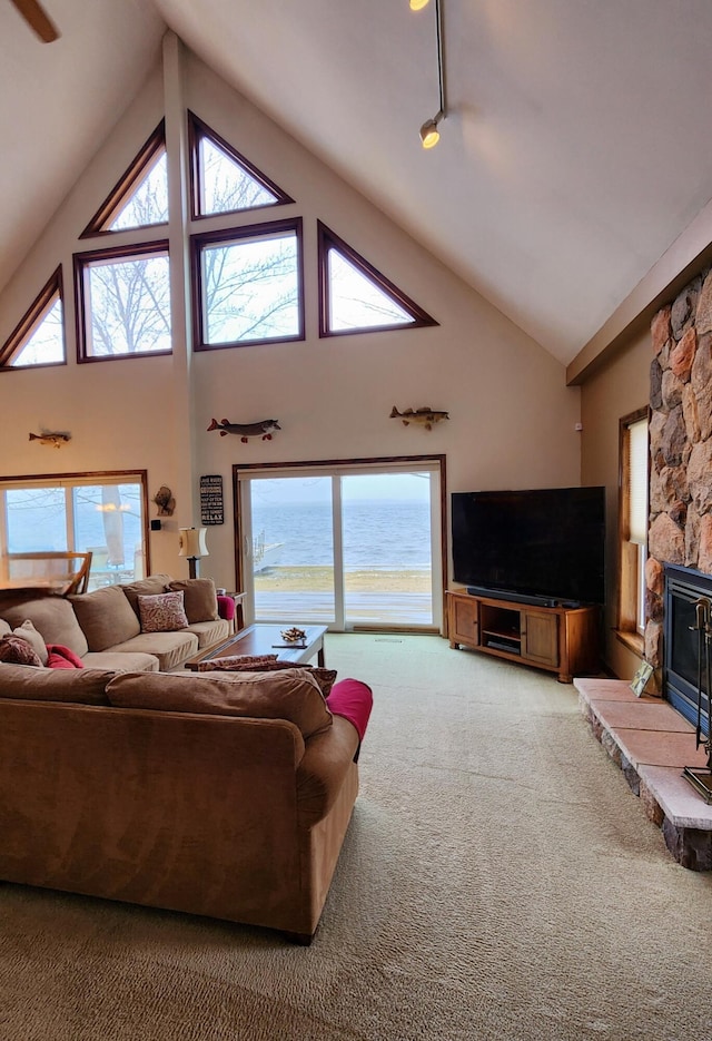 carpeted living room with high vaulted ceiling