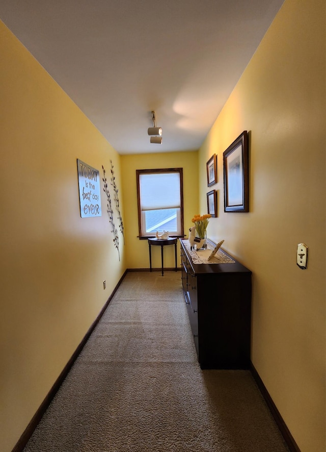 hallway with carpet flooring and baseboards