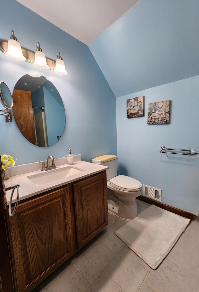 bathroom with toilet, vanity, visible vents, and vaulted ceiling