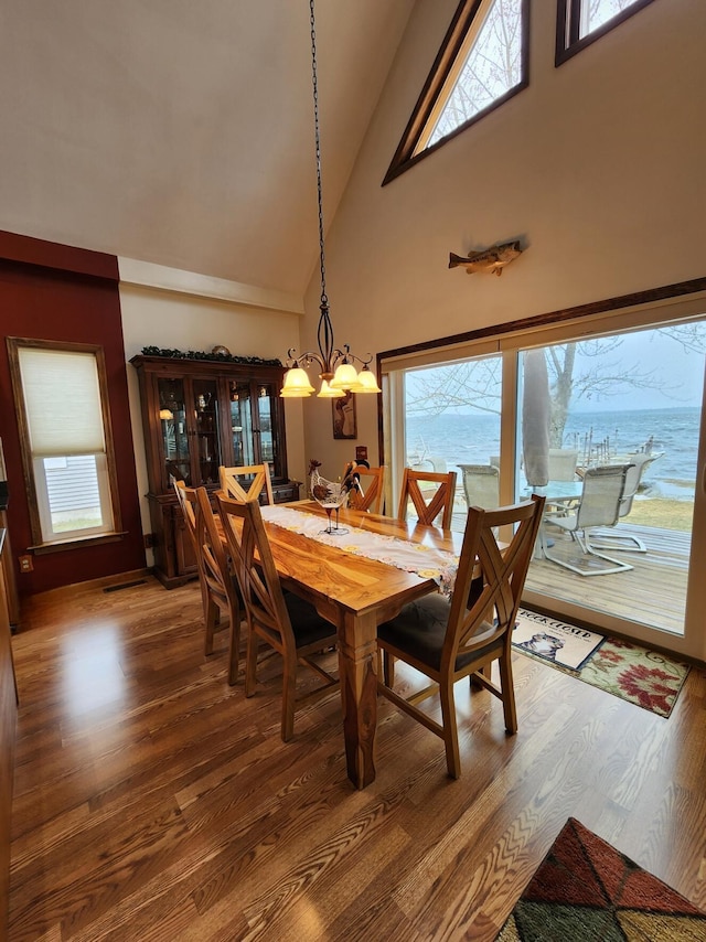dining room featuring visible vents, high vaulted ceiling, a notable chandelier, and wood finished floors