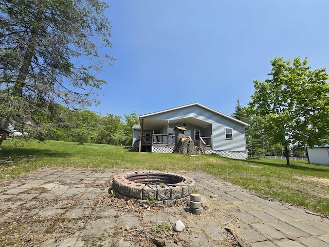 1793 W Kittle Rd, Mio, MI 48647 - back of property featuring an outdoor fire pit, a yard, and a porch