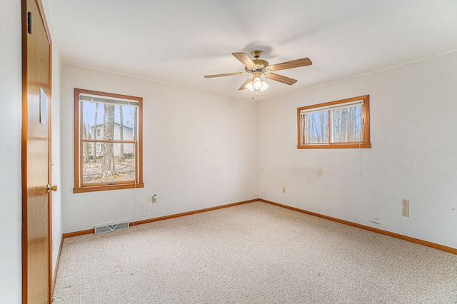 4640 Hiawatha Dr, Cheboygan, MI 49721 - unfurnished room featuring a ceiling fan, a healthy amount of sunlight, visible vents, and carpet
