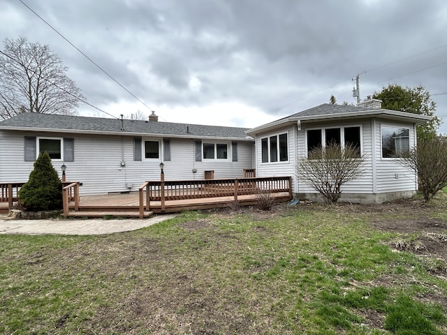 2141 S First Ave, Alpena, MI 49707 - rear view of property with a lawn, a chimney, a shingled roof, and a wooden deck