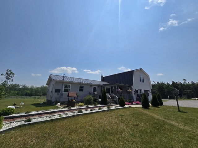 1300 N Perry Creek Rd, Fairview, MI 48621 - rear view of property featuring a metal roof, a chimney, a gambrel roof, and a standing seam roof