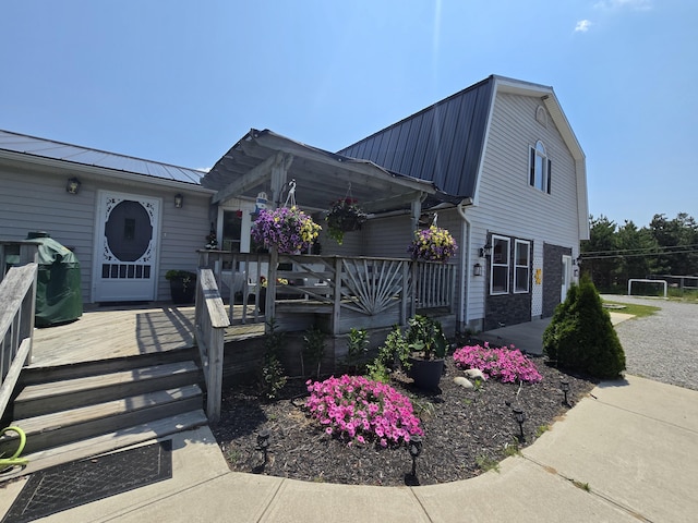 1300 N Perry Creek Rd, Fairview, MI 48621 - view of front of property with a metal roof, a gambrel roof, and a wooden deck