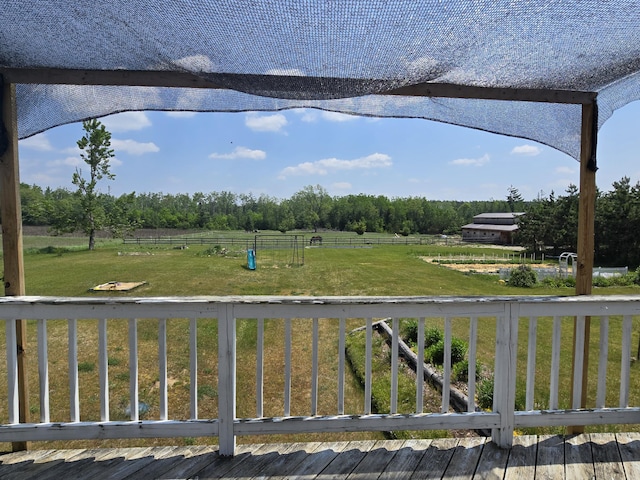 1300 N Perry Creek Rd, Fairview, MI 48621 - view of green lawn featuring a rural view, a wooden deck, and view of scattered trees
