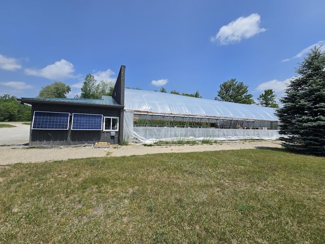 1300 N Perry Creek Rd, Fairview, MI 48621 - back of property with a metal roof, an outbuilding, a lawn, and an exterior structure