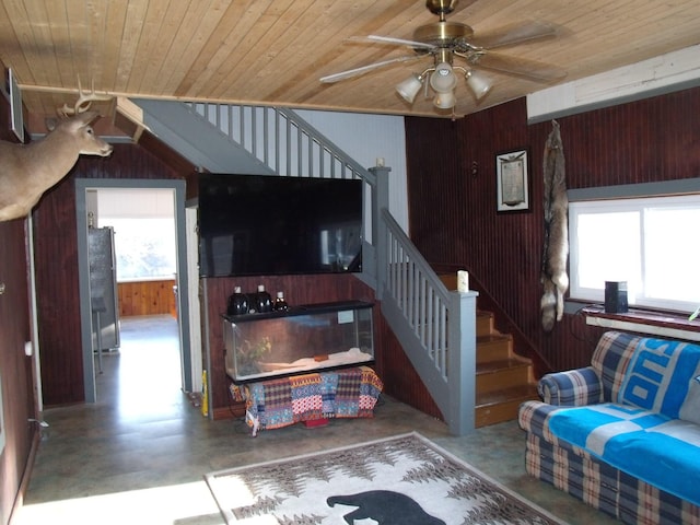 3468 W Nye Rd, Hessel, MI 49745 - living area with wooden ceiling, stairway, ceiling fan, concrete floors, and wooden walls