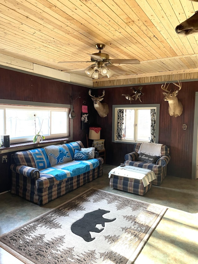 3468 W Nye Rd, Hessel, MI 49745 - living area with wooden ceiling, healthy amount of natural light, wood walls, concrete flooring, and a ceiling fan