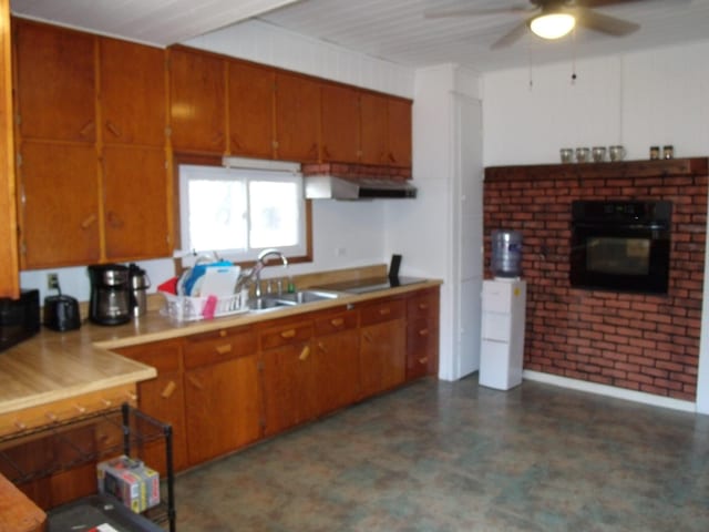 3468 W Nye Rd, Hessel, MI 49745 - kitchen with oven, dark flooring, ceiling fan, and brown cabinets