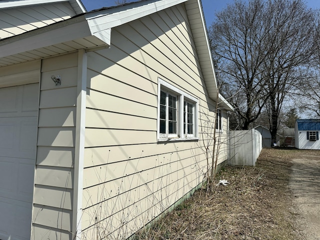 view of side of home featuring a storage unit and an outbuilding