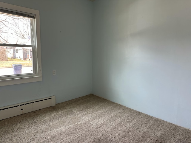carpeted spare room featuring a baseboard radiator