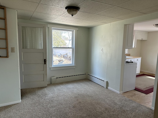unfurnished room featuring light carpet, baseboards, a paneled ceiling, baseboard heating, and washer / clothes dryer