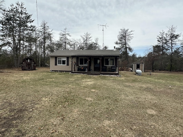back of property with a lawn and covered porch