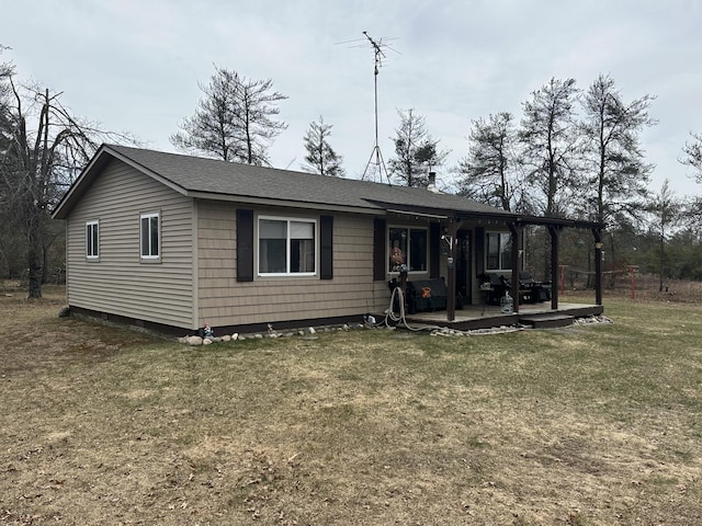 view of front of home with a shingled roof and a front yard