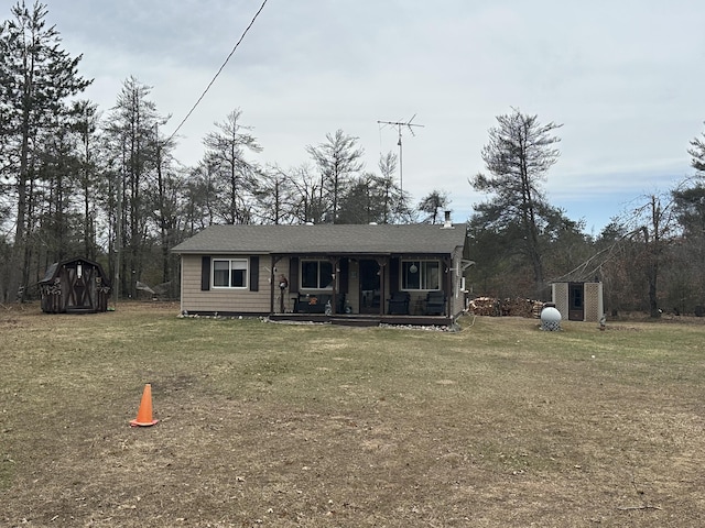 rear view of house featuring a lawn and covered porch