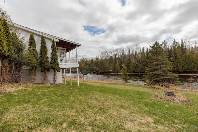 view of yard featuring a forest view and a water view
