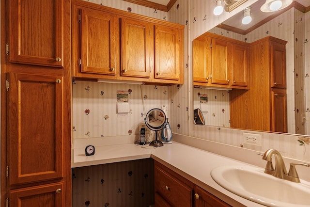 bathroom with wallpapered walls and vanity