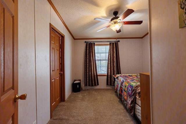 bedroom with carpet floors, a textured ceiling, crown molding, and a ceiling fan