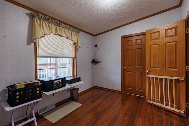 home office featuring dark wood finished floors, visible vents, a textured ceiling, and ornamental molding