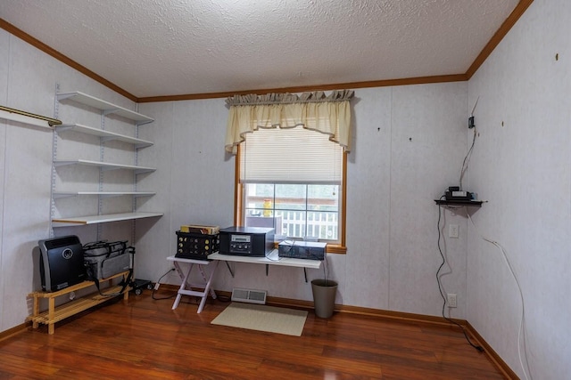 office area featuring wood finished floors, visible vents, a textured ceiling, and crown molding