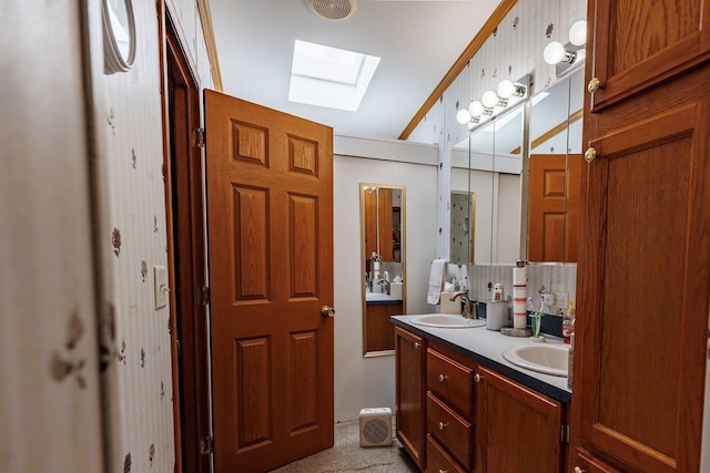 bathroom featuring double vanity, visible vents, a skylight, and a sink