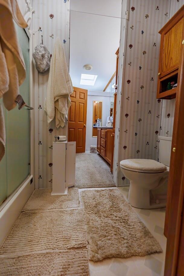 bathroom featuring vanity, bath / shower combo with glass door, and toilet