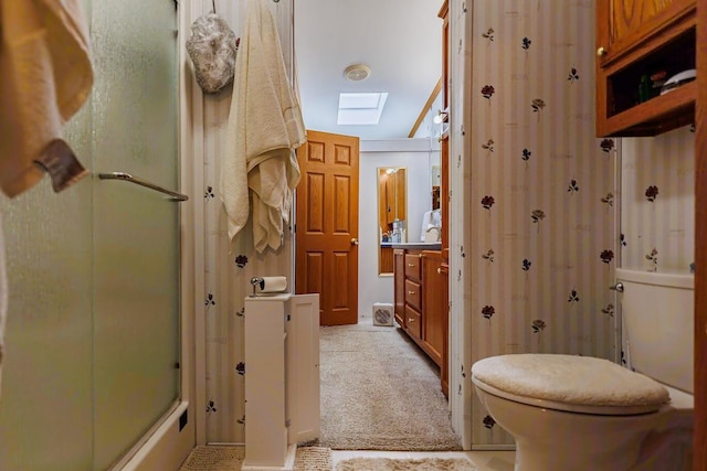 full bathroom with toilet, a skylight, and enclosed tub / shower combo