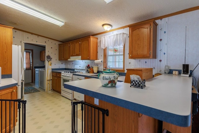kitchen with a peninsula, extractor fan, white appliances, light floors, and ornamental molding