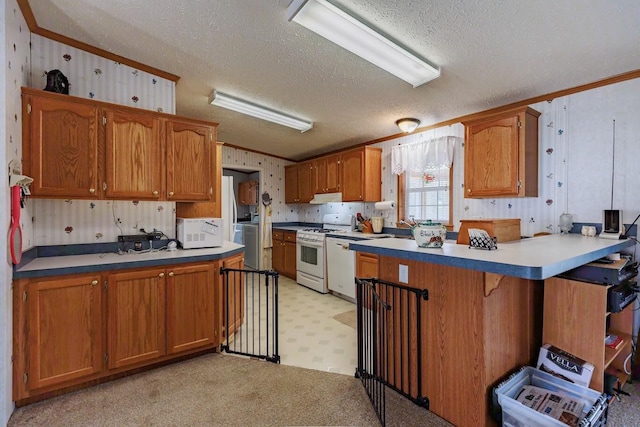 kitchen featuring a peninsula, a textured ceiling, crown molding, and white appliances