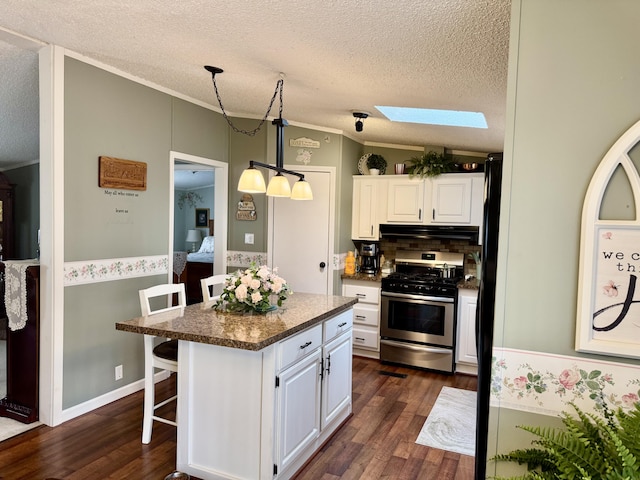 10525 Alpenhof Dr, Grayling, MI 49738 - kitchen with stainless steel gas range, under cabinet range hood, dark wood-style floors, white cabinets, and a textured ceiling