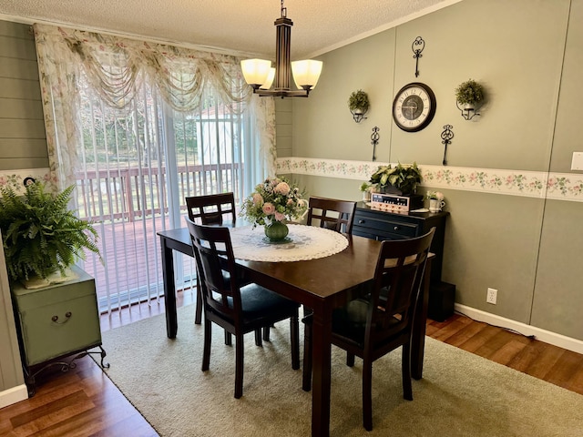 10525 Alpenhof Dr, Grayling, MI 49738 - dining room featuring a chandelier, a textured ceiling, wood finished floors, and crown molding