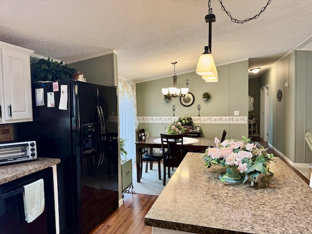 10525 Alpenhof Dr, Grayling, MI 49738 - kitchen featuring ornamental molding, black fridge, white cabinetry, wood finished floors, and a chandelier