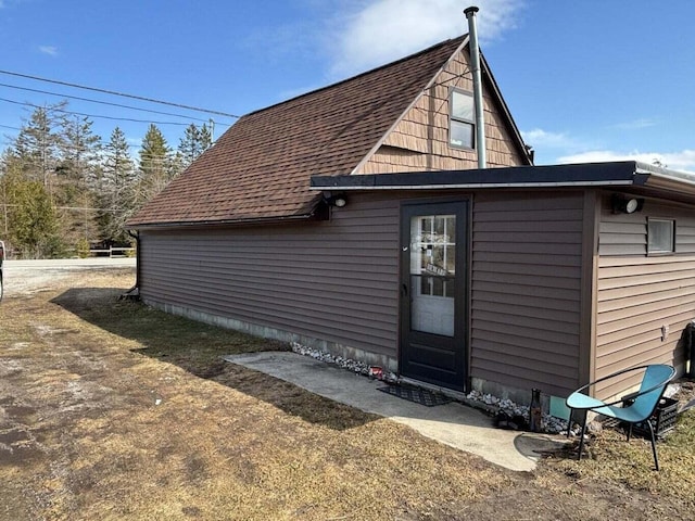 rear view of house with a shingled roof