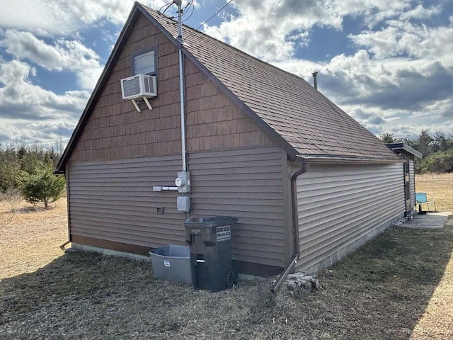 view of home's exterior with cooling unit and roof with shingles